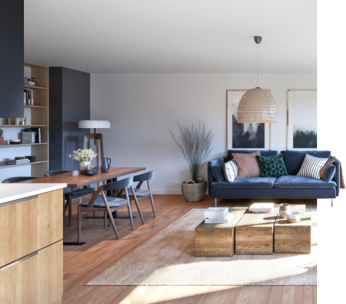 Salon moderne avec canapé bleu, table basse en bois, cuisine ouverte et baies vitrées.