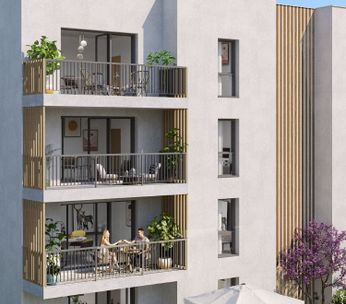 Immeuble résidentiel moderne de trois étages avec façade claire, balcons, entouré de végétation.