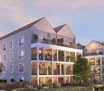 Immeuble résidentiel moderne au coucher de soleil avec façades colorées et espaces verts environnants.