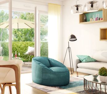 Cuisine-salon lumineux avec îlot central, mobilier bois clair et grandes baies vitrées donnant sur jardin.