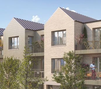 Immeuble résidentiel moderne avec façade beige, grandes fenêtres et végétation environnante sous ciel bleu.