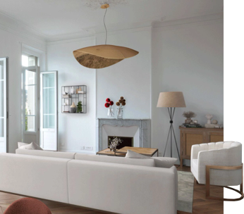 Salon moderne avec canapé blanc, foyer intégré, fauteuil beige et décoration minimaliste.