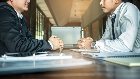 Deux personnes autour d'une table avec des papiers 