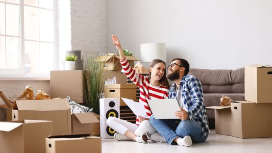 Famille emballant des cartons de déménagement dans un salon lumineux.