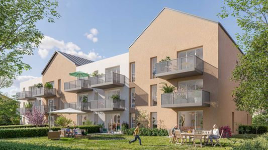 Immeuble résidentiel moderne aux façades en brique et pierre, avec balcons, entouré de verdure et ciel bleu.