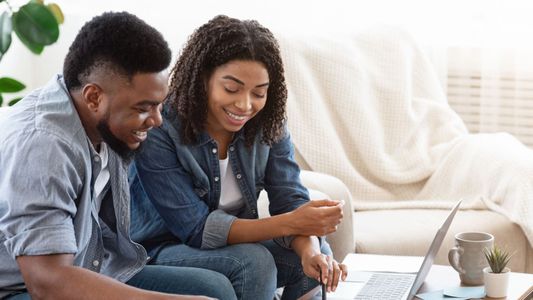 Père et enfant assis ensemble regardant une tablette numérique.