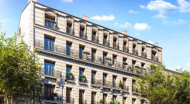 Immeuble haussmannien parisien de cinq étages avec façade beige, fenêtres régulières et arbres environnants sous ciel bleu.