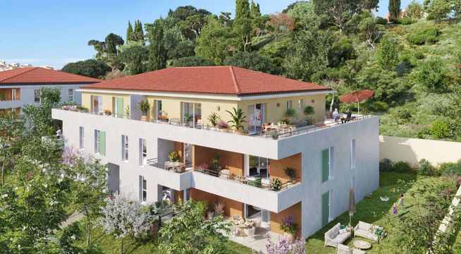 Immeuble résidentiel moderne aux façades colorées, entouré de végétation sur une pente boisée.