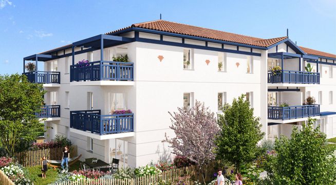 Immeuble résidentiel blanc de trois étages avec balcons, entouré de verdure sous ciel dégagé.
