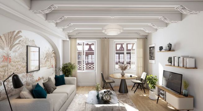 Salon moderne lumineux avec canapé gris, plantes vertes, portes-fenêtres et parquet clair.