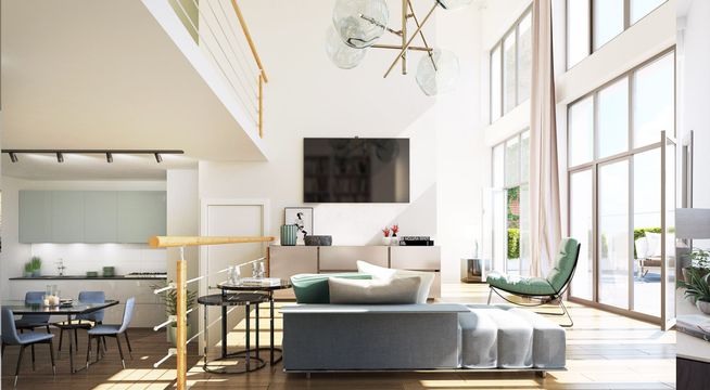 Salon moderne aux hauts plafonds avec canapé gris, téléviseur mural et cuisine ouverte en arrière-plan.