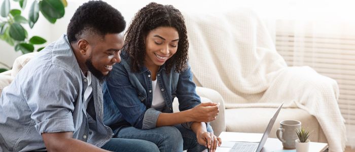 Père et enfant assis ensemble regardant une tablette numérique.
