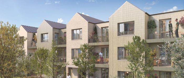 Immeuble résidentiel moderne aux façades beiges avec balcons et verdure, sous ciel bleu.